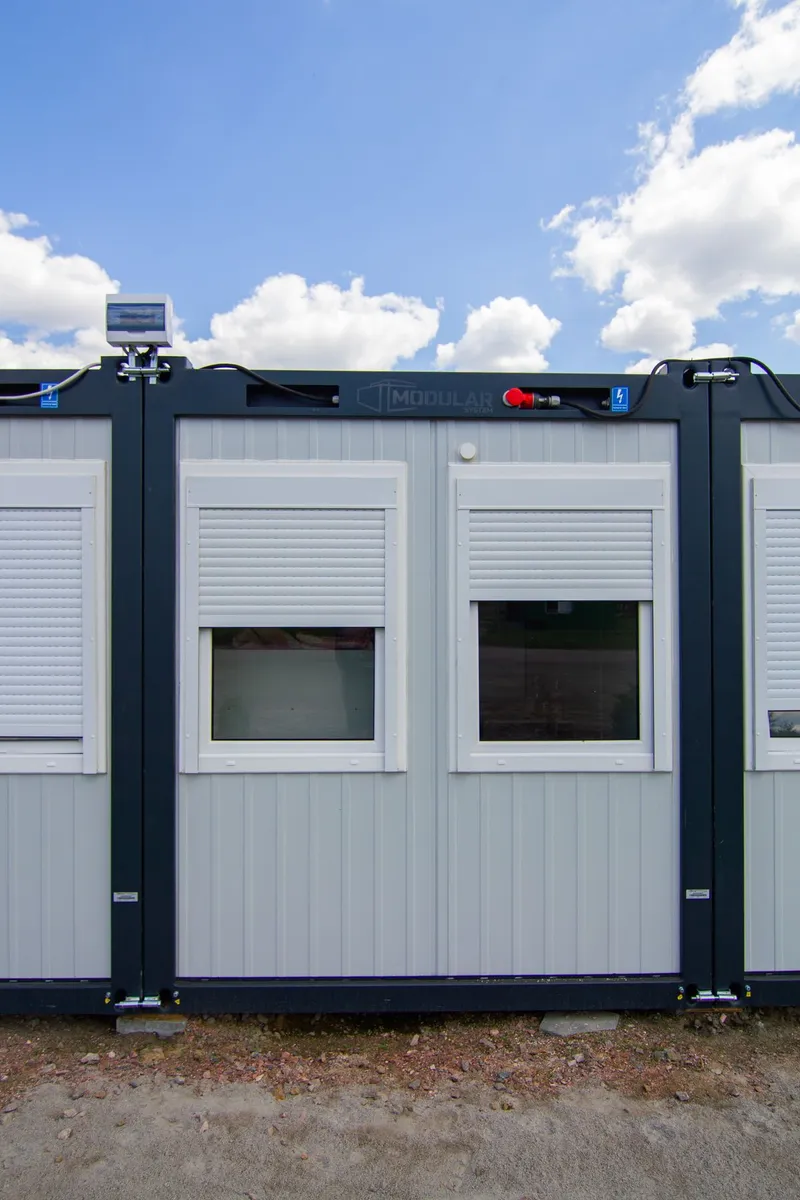 Container modular de birou văzut din față, cu două ferestre cu rulouri
