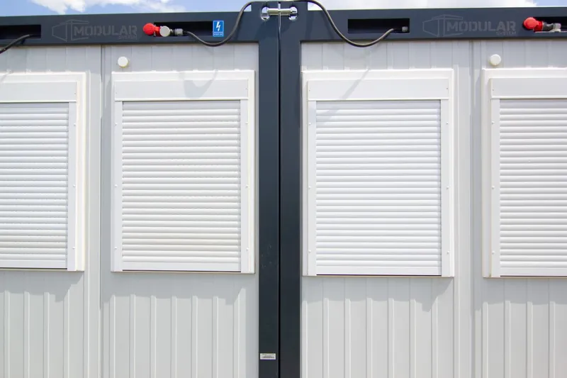 Detaliu cu ferestrele și rulourile exterioare ale unui container modular